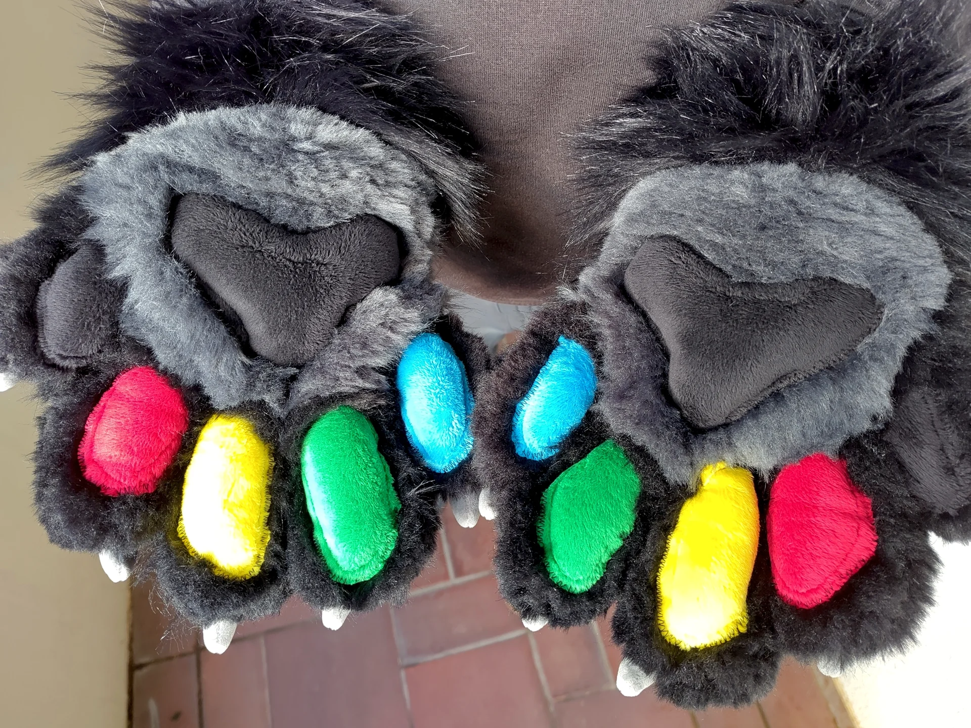 Puffy paws with black faux fur and red, green, blue, yellow and black paw pads.