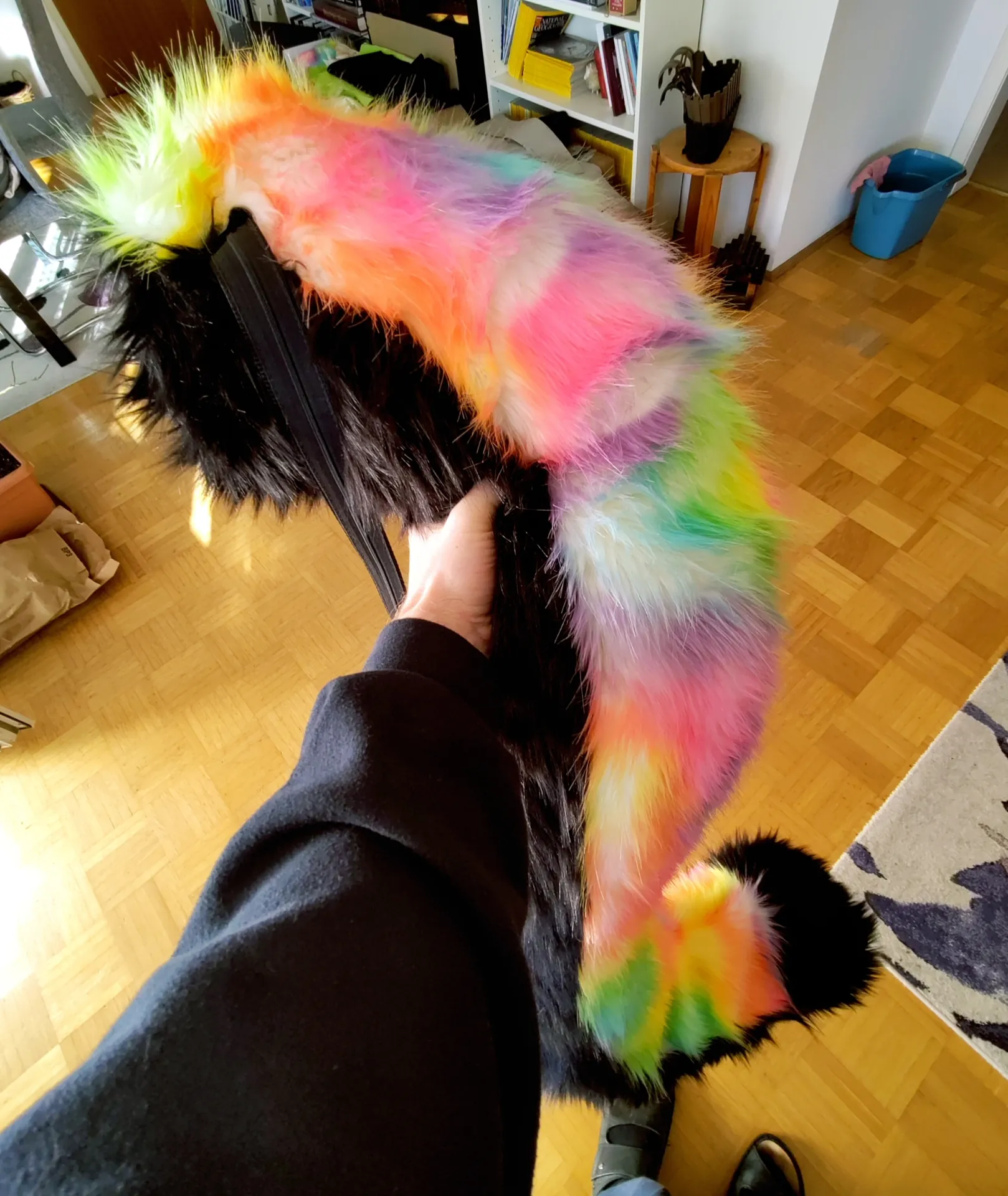 Me holding the finished tail. Ignore the chaos in the room! There is a black belt attached to it already.